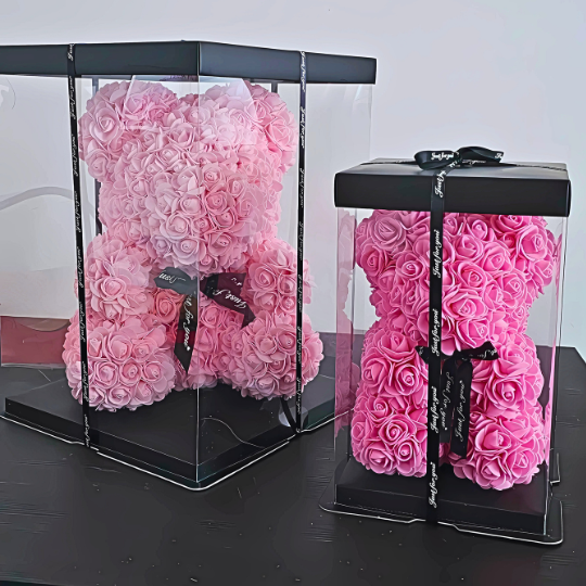 Elegant My Pink Forever rose teddy bear displayed inside a transparent gift box tied with a satin ribbon, available in Forever Petite and Forever Grand sizes, ideal as a romantic gift or thoughtful gesture for loved ones and friends. My Pink Forever - Snug Box