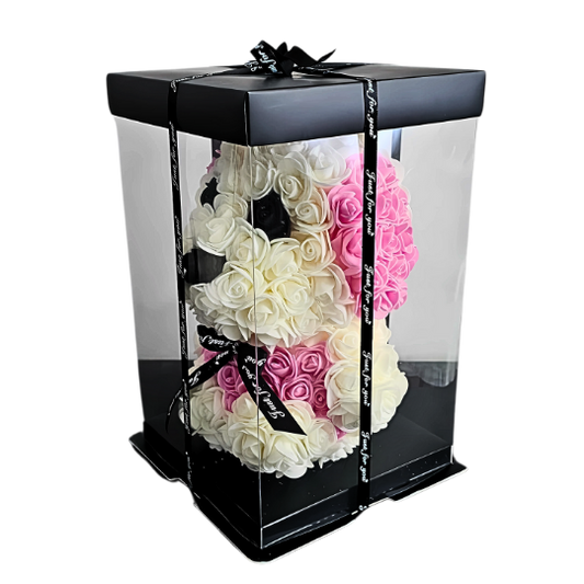 Handcrafted white rose puppy with soft pink rose ears and black rose eyes, beautifully packaged in a clear display box with satin ribbon, perfect gift for birthdays, new babies, and playful keepsakes. ideal for gifting as a charming and lasting symbol of affection and innocence. My Playful Forever - Snug Box